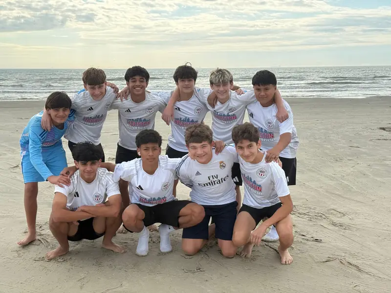 Juniors players smiling together on the beach during a team trip