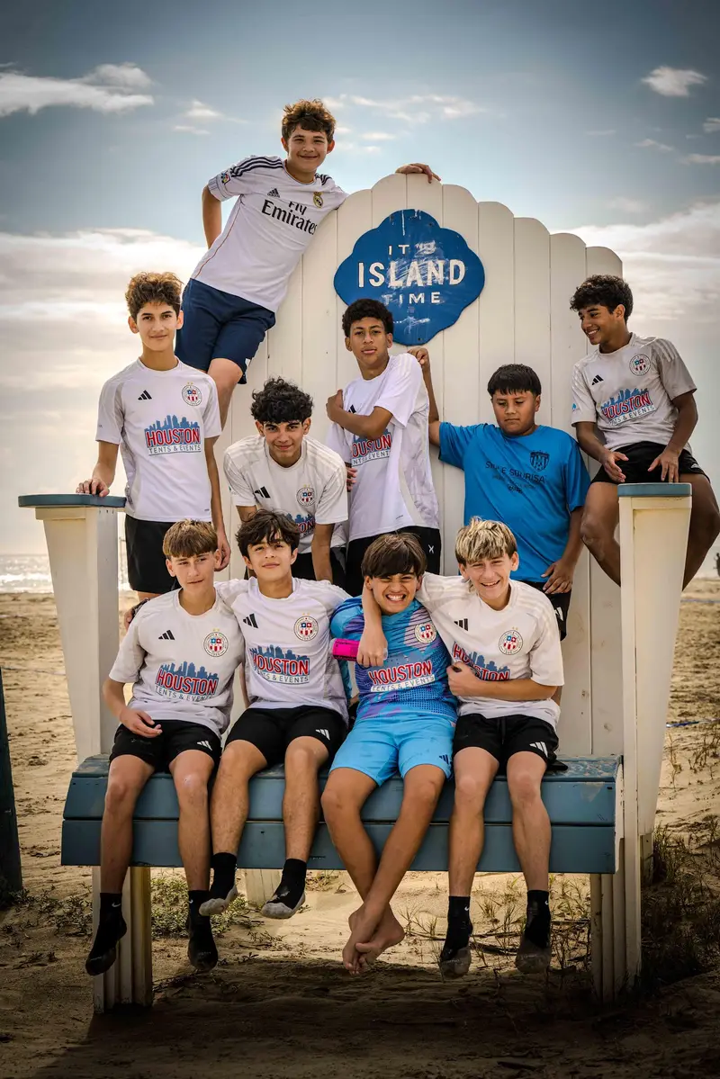 The team posing on a giant beach chair during a team trip